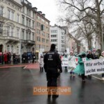 Der Spitze des Demonstrationszuges wird die rote Karte gezeigt
